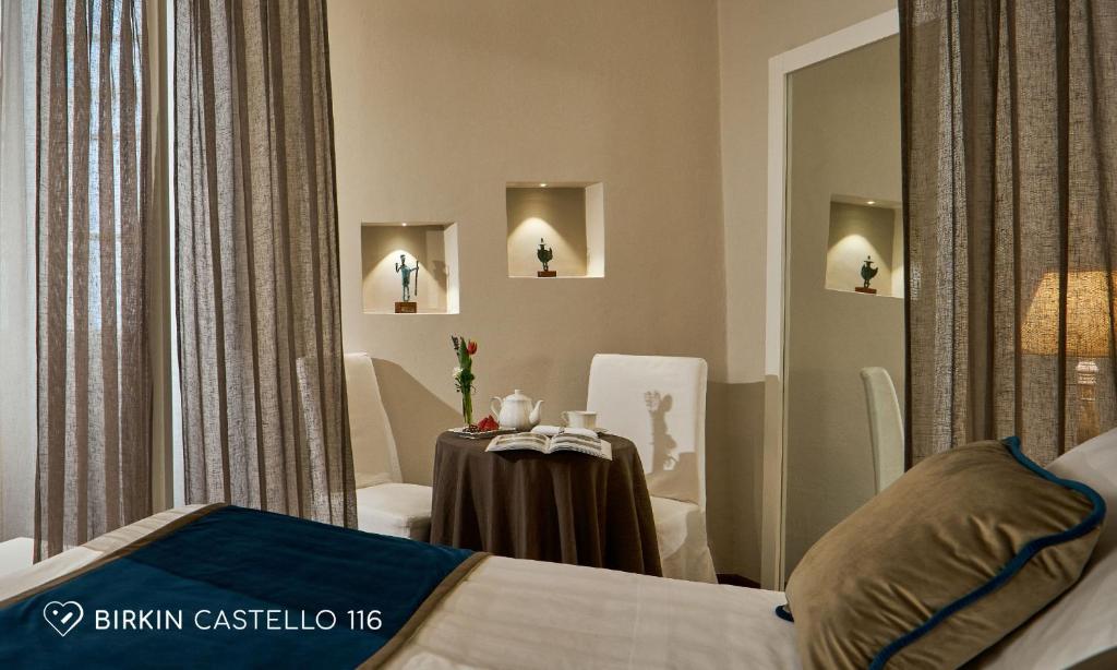 a bedroom with a table and chairs and a mirror at Albergo Diffuso Birkin Castello in Cagliari
