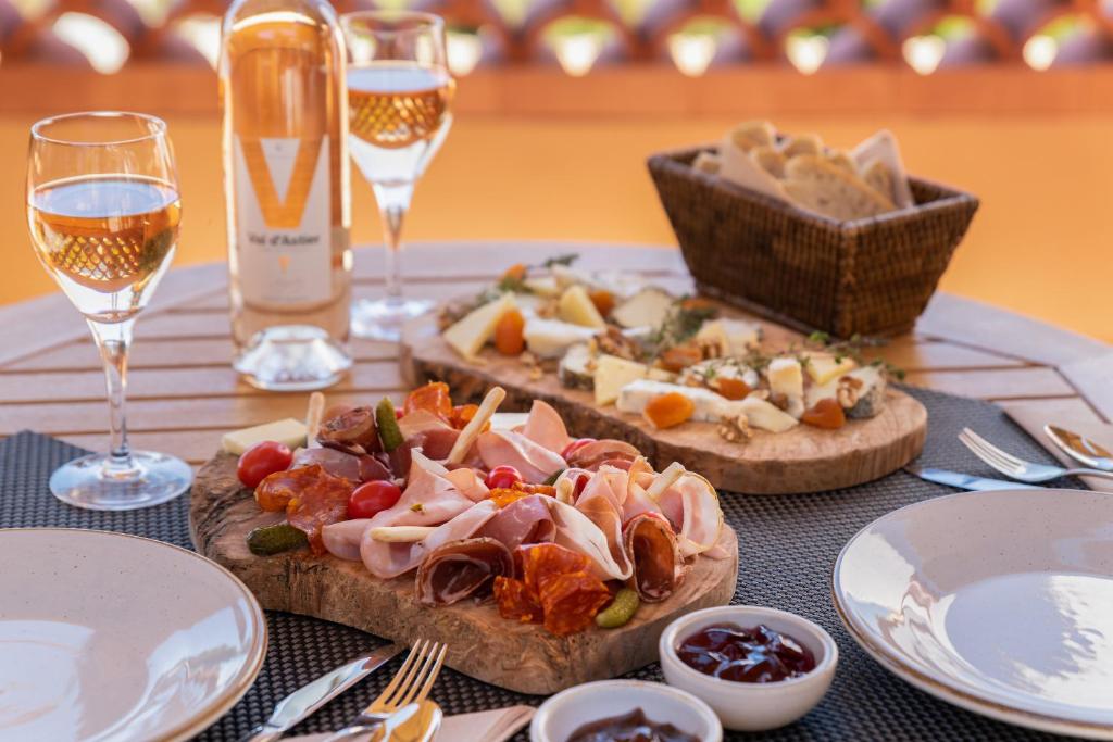 a table with two pizzas and glasses of wine at Les Terrasses du Bailli in Rayol-Canadel-sur-Mer