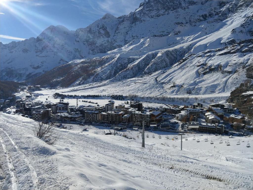 a town in the snow with mountains in the background at Le Cherillon Apartment in Breuil-Cervinia