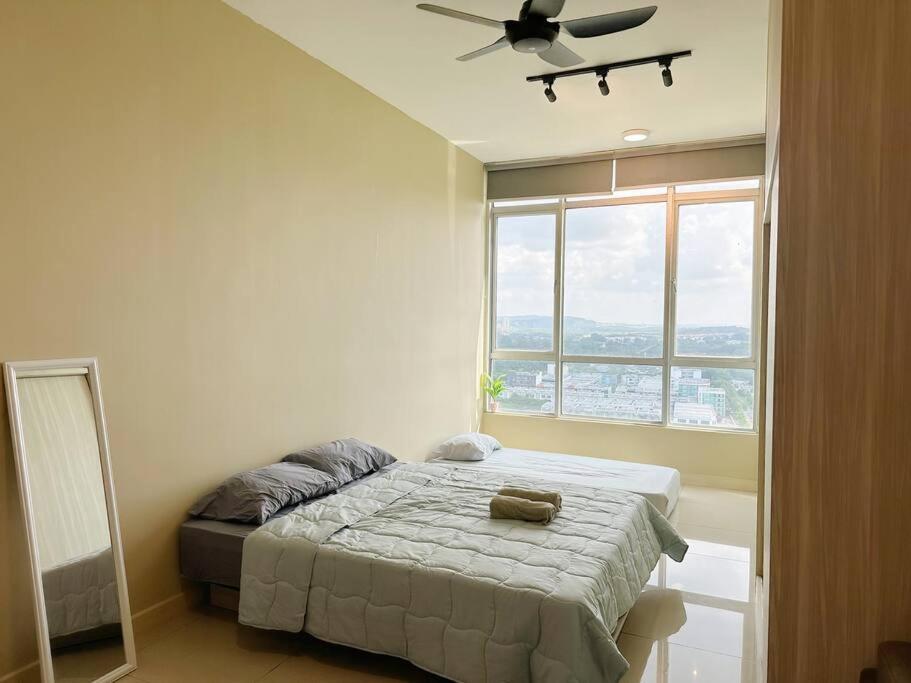 een slaapkamer met een bed en een groot raam bij JB City Sunset Studio Paradigm Sutera & UTM Wifi 4pax in Johor Bahru