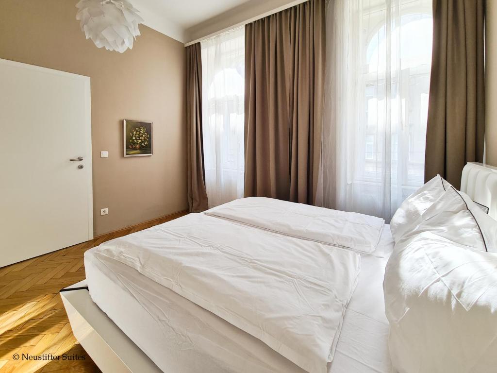 a white bed in a bedroom with a window at Appartement Cervantes 9 in Vienna