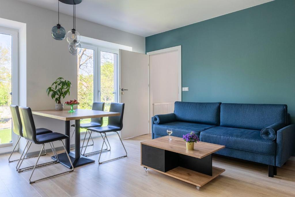 uma sala de estar com um sofá azul e uma mesa em APARTAMENTY ZDROJOWA 9 em Duszniki Zdrój