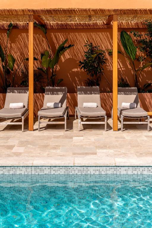 a swimming pool with two lounge chairs next to a swimming pool at Les Terrasses du Bailli in Rayol-Canadel-sur-Mer