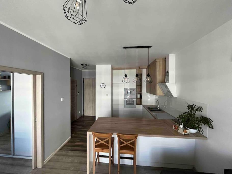 a kitchen and dining room with a table and chairs at Apartament Letnica in Gdańsk