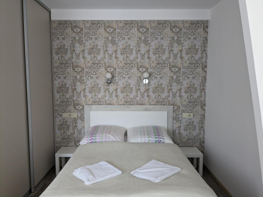 um quarto com uma cama com duas toalhas brancas em Sea of ​​Nida em Nida