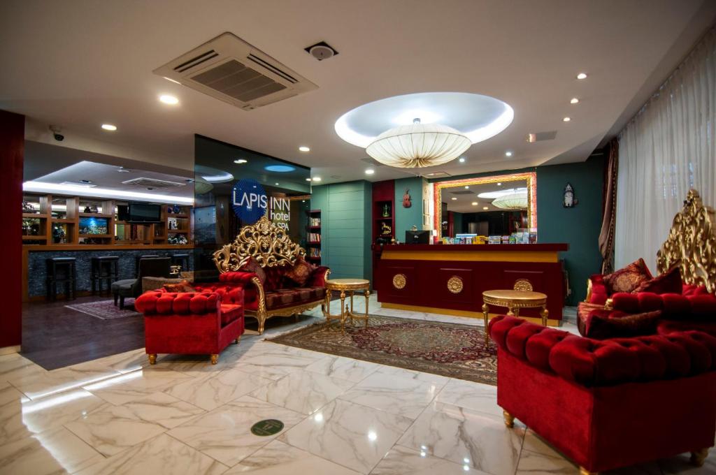 a lobby with red chairs and a bar in a store at Lapis Inn Hotel & Spa ( Ex. Ambassador Hotel) in Istanbul