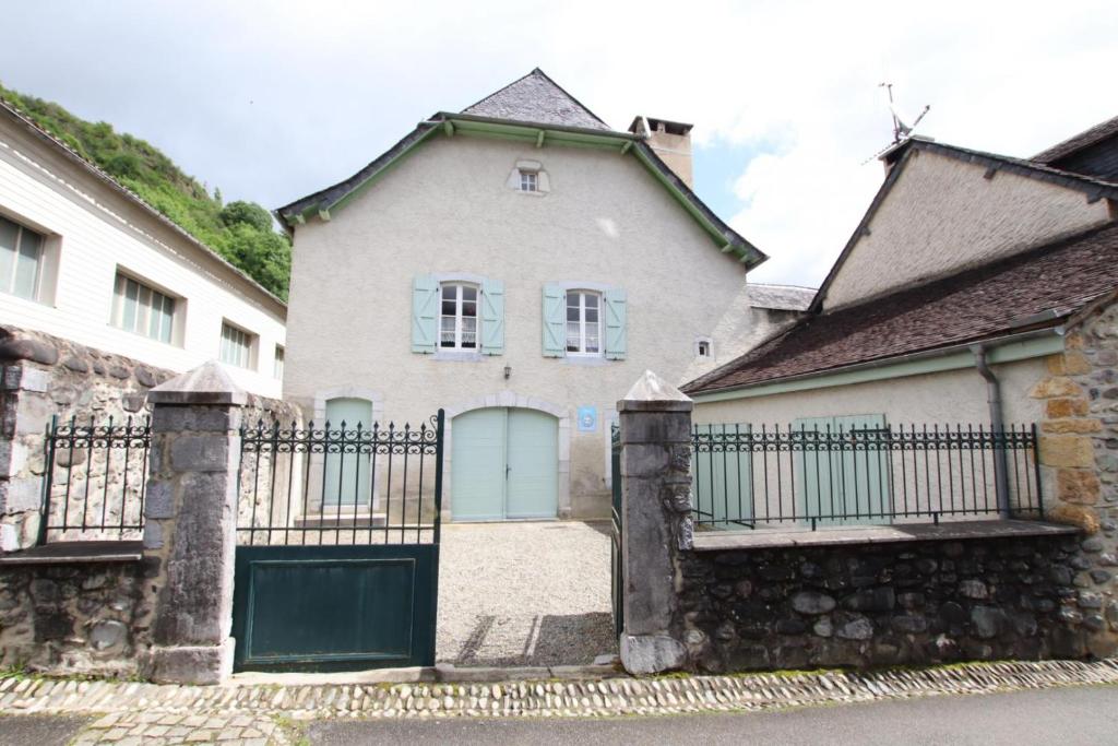 uma casa com um portão e uma parede de pedra em Chez ladarre em Osse-en-Aspe