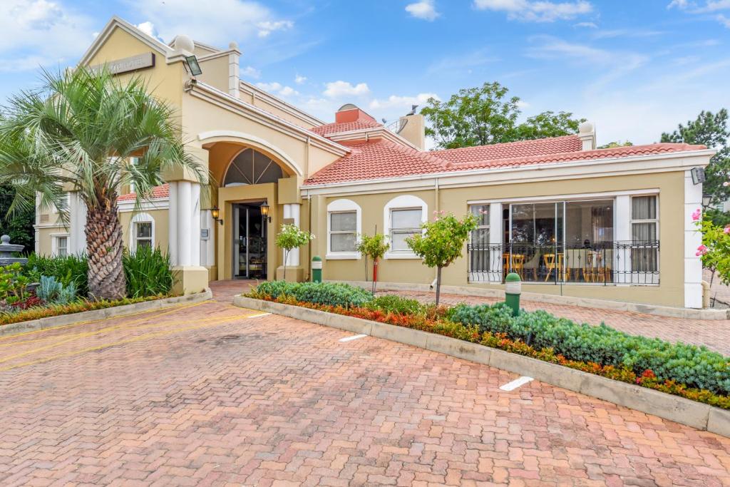 a house with a brick driveway in front of it at Mercure Johannesburg Midrand in Midrand