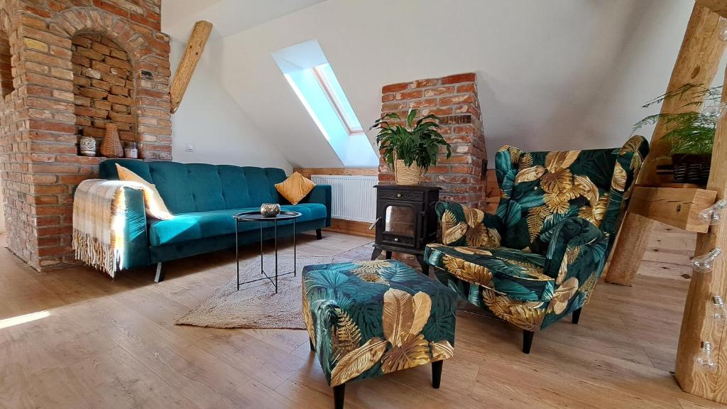 a living room with blue furniture and a brick wall at Ostoja Leśna Cisza in Purda
