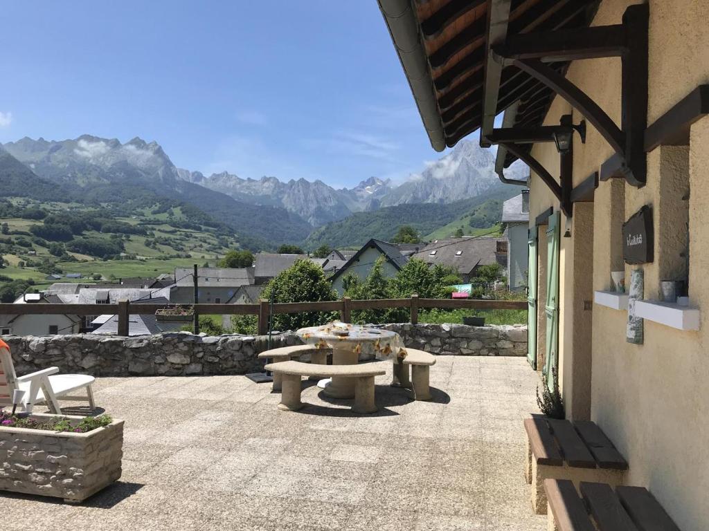 un patio con mesa de picnic y vistas a las montañas en Le cailhabas, en Lescun