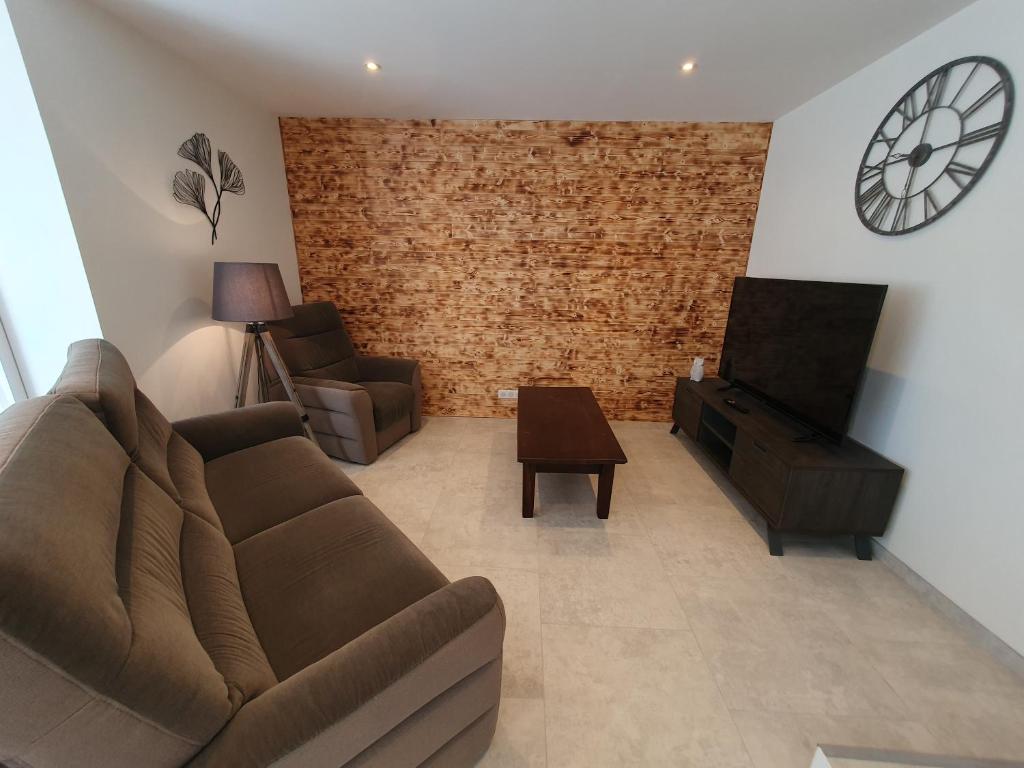a living room with a couch and a tv at Gîte de Saint Ladre Le Hibou, proche Roissy CDG NEUF in Othis