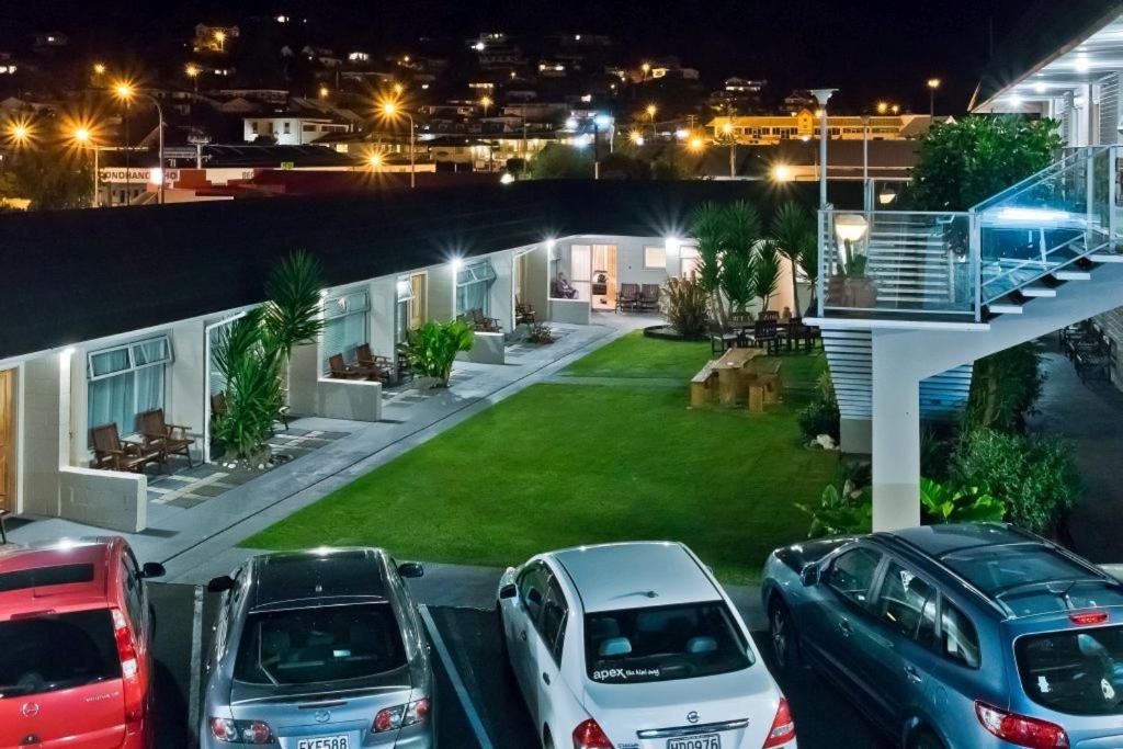 eine Gruppe von Autos, die nachts vor einem Haus geparkt werden in der Unterkunft Picton Accommodation Gateway Motel in Picton