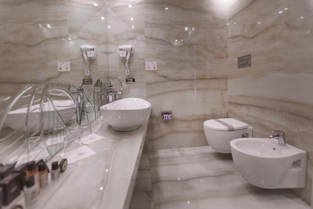 a bathroom with two sinks and a toilet at Park Hotel Imperial in Limone sul Garda