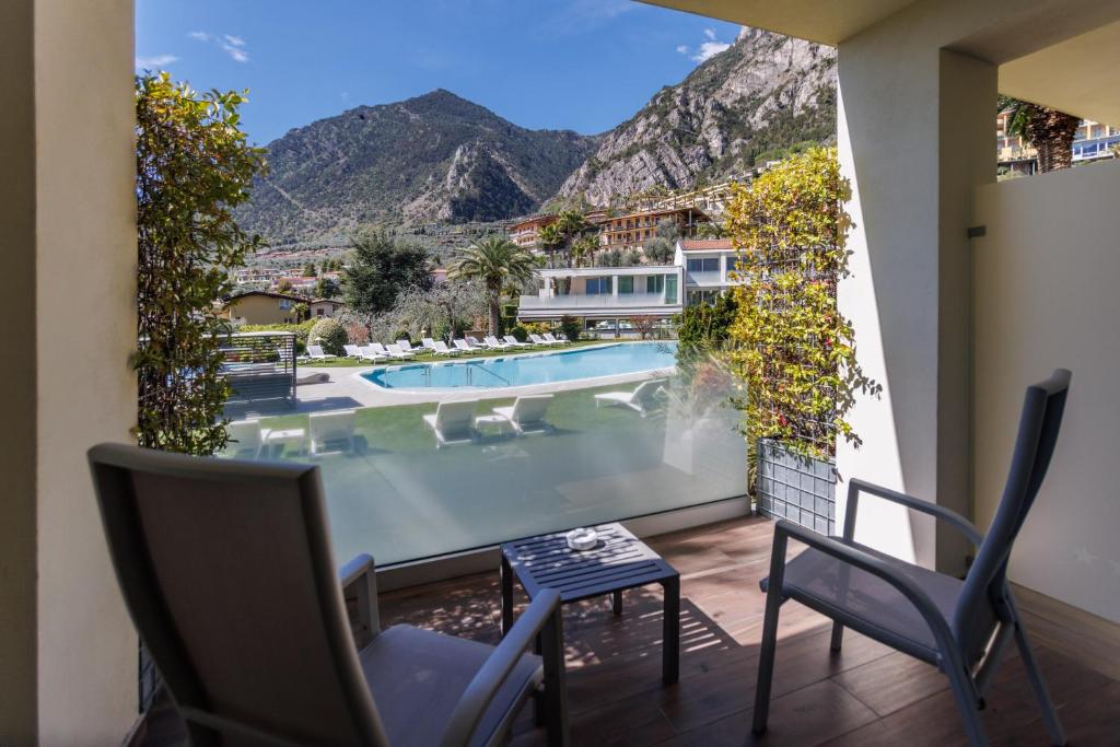 a balcony with a view of a pool and mountains at Park Hotel Imperial in Limone sul Garda