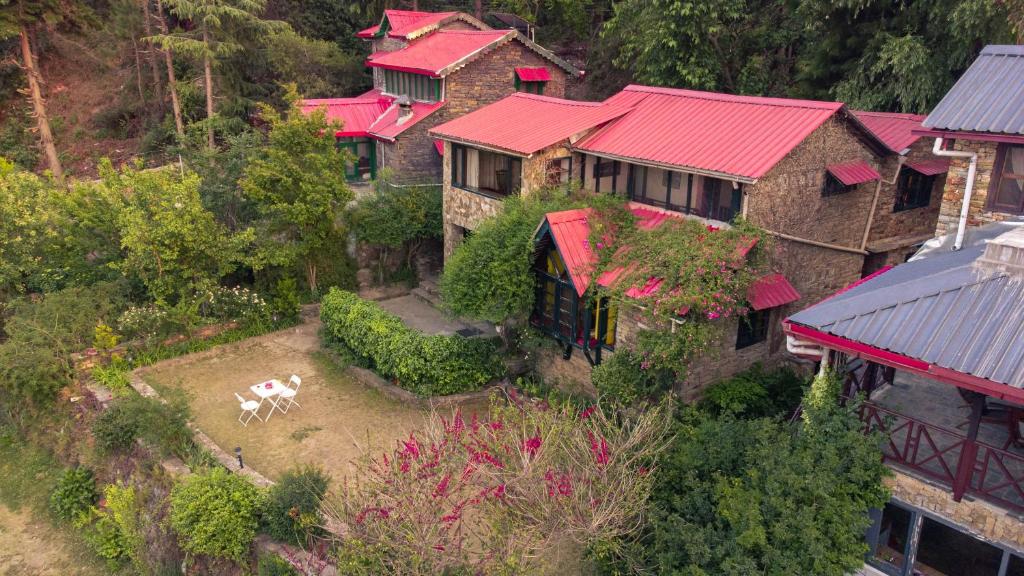 an aerial view of a house with a cow in the yard at Hostie Onella - Private 3BHK Mountain Chalet with breathtaking Himalayan views in Rānīkhet