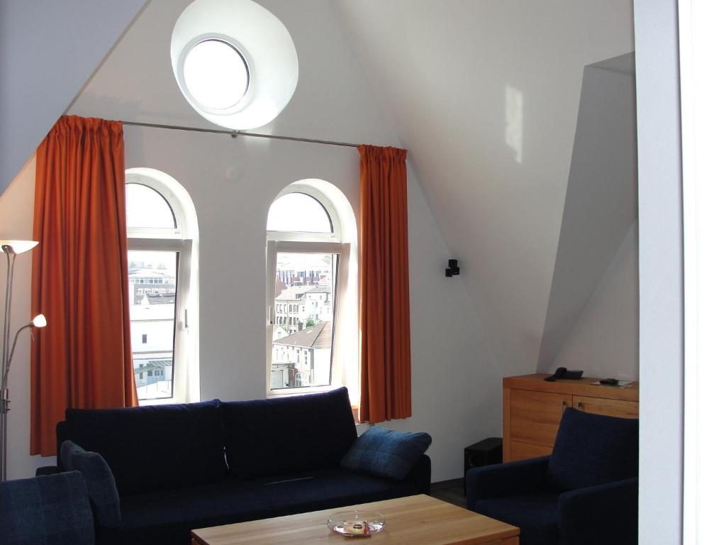 uma sala de estar com um sofá e duas janelas em Ferienwohnung Berliner Hof em Kiel