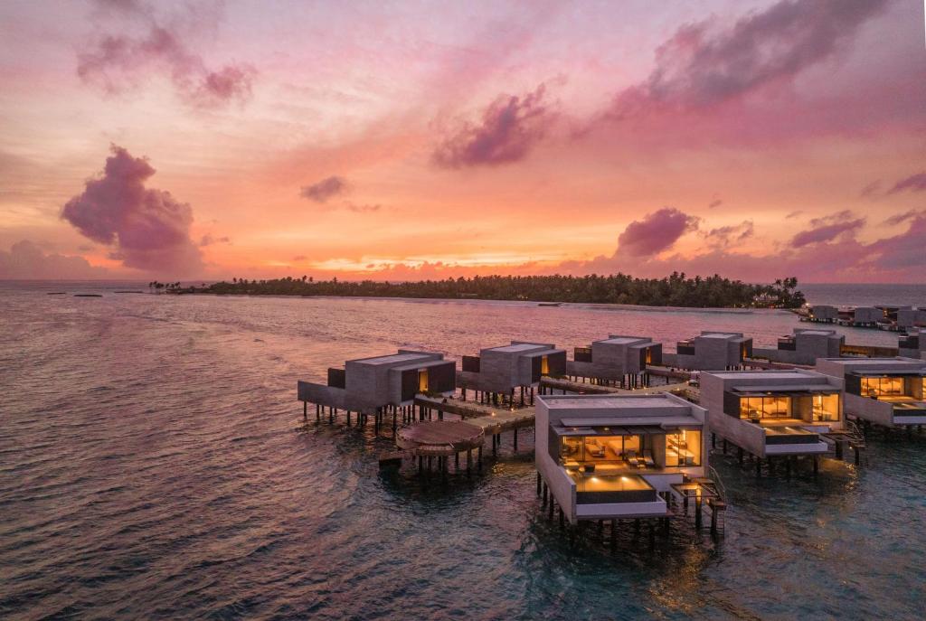 a resort in the middle of the water at sunset at Alila Kothaifaru Maldives 