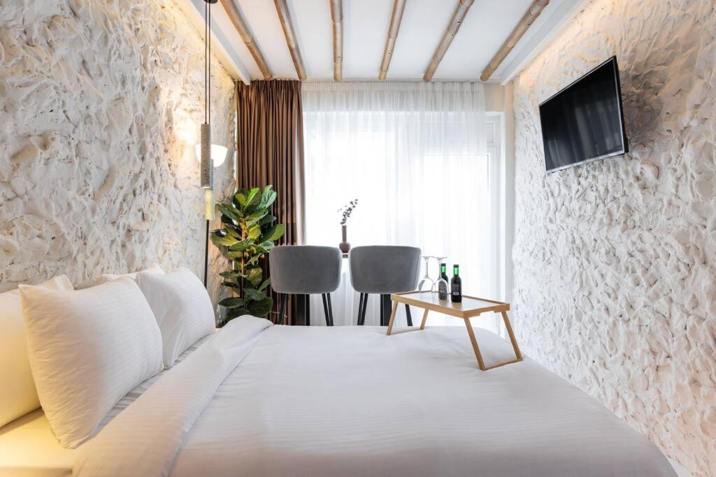 um quarto com uma cama branca e uma mesa em Stylish & Tiny Room-City Center em Tessalônica