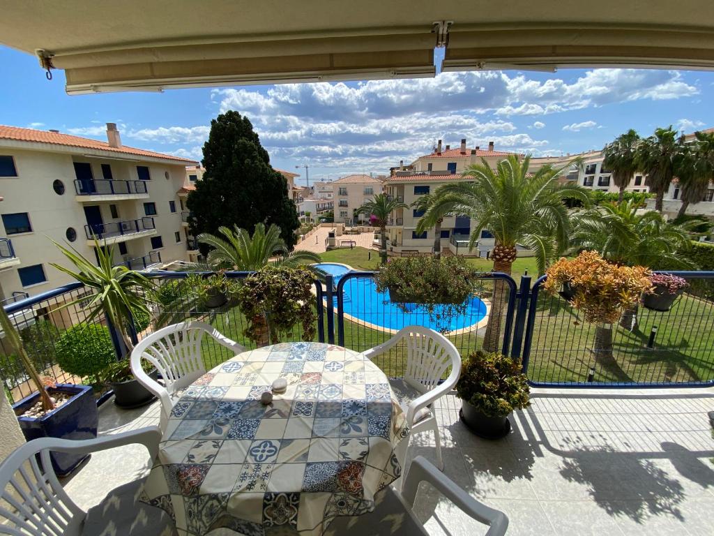 uma varanda com mesa e cadeiras e uma piscina em Apartamentos Porta Mediterranea Altamar em Alcossebre