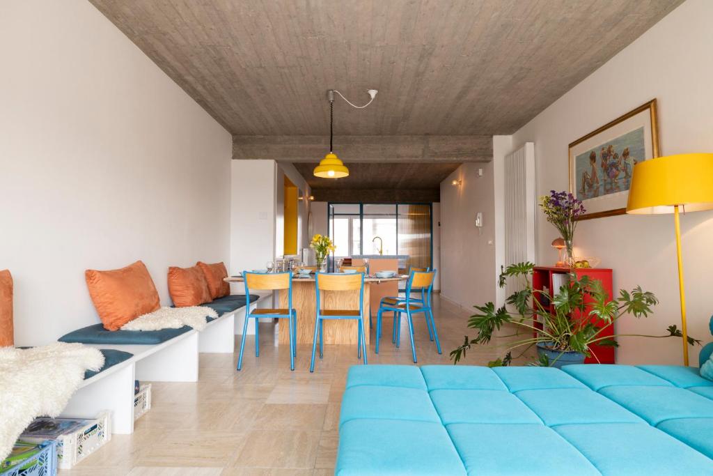 uma sala de estar com um sofá azul e uma mesa em Spacious family flat near the beach (6-8 pers) em Koksijde