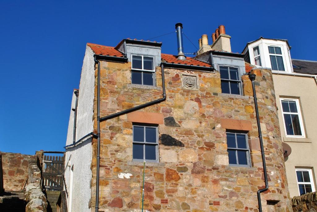 an old stone building with a blue sky in the background at The Loft- charming character cottage in East Neuk in Anstruther