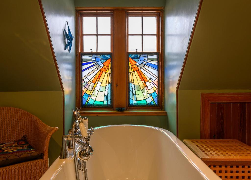 a bath tub in a bathroom with a stained glass window at Crail Posthouse - 19th Century traditional house in Crail