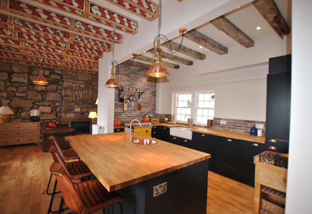 - une cuisine avec un comptoir en bois dans l'établissement Seaspray- harbourfront home in idyllic location, à Pittenweem