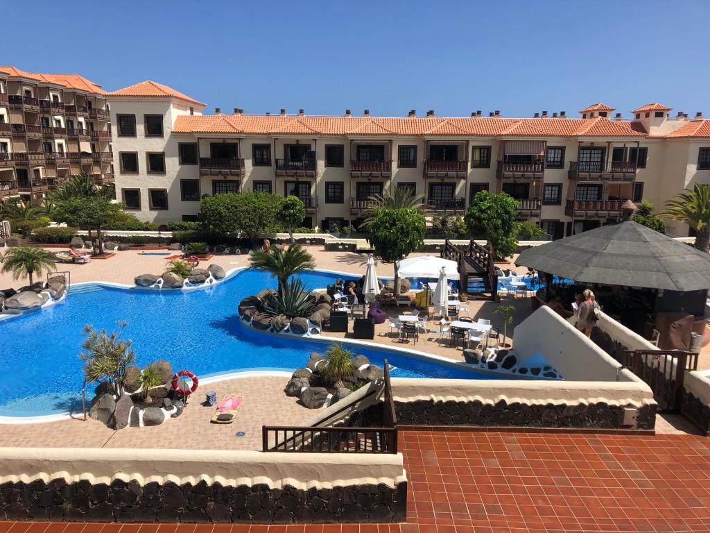 an overhead view of a resort pool with buildings in the background at Balcon Mar Larisa in Costa Del Silencio