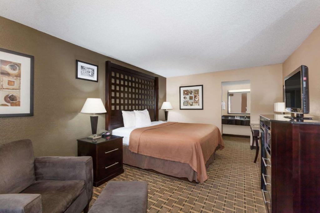 a hotel room with a bed and a couch at Super 8 by Wyndham Atoka in Atoka