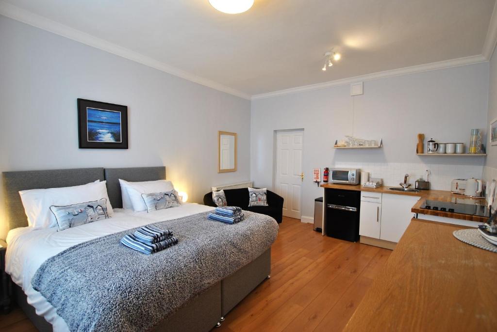 1 dormitorio con 1 cama grande y cocina en Market Apartment- harbourfront studio Pittenweem, en Pittenweem