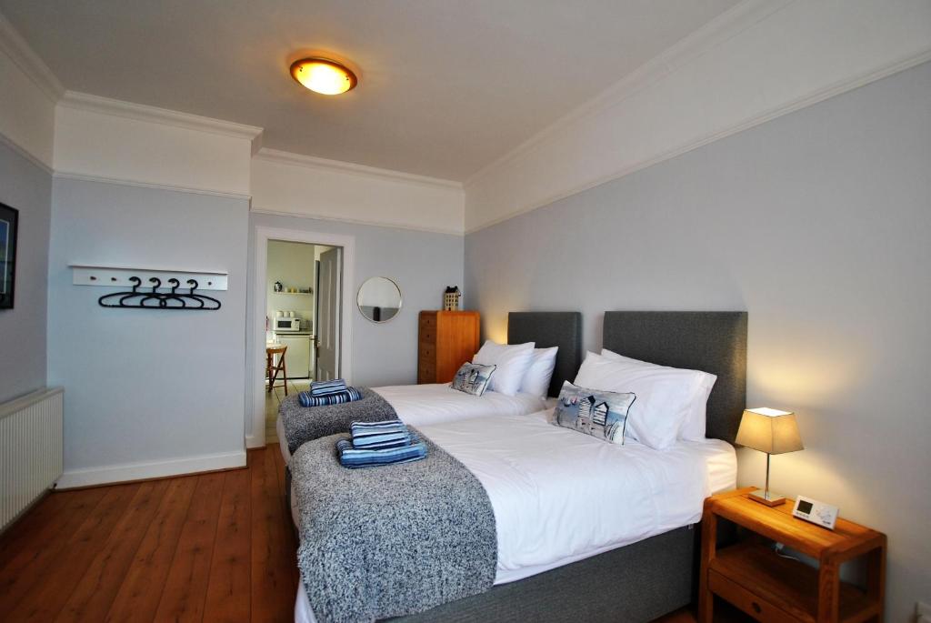- une chambre avec un grand lit blanc et une table dans l'établissement Gyles Apartment - harbourfront studio Pittenweem, à Pittenweem