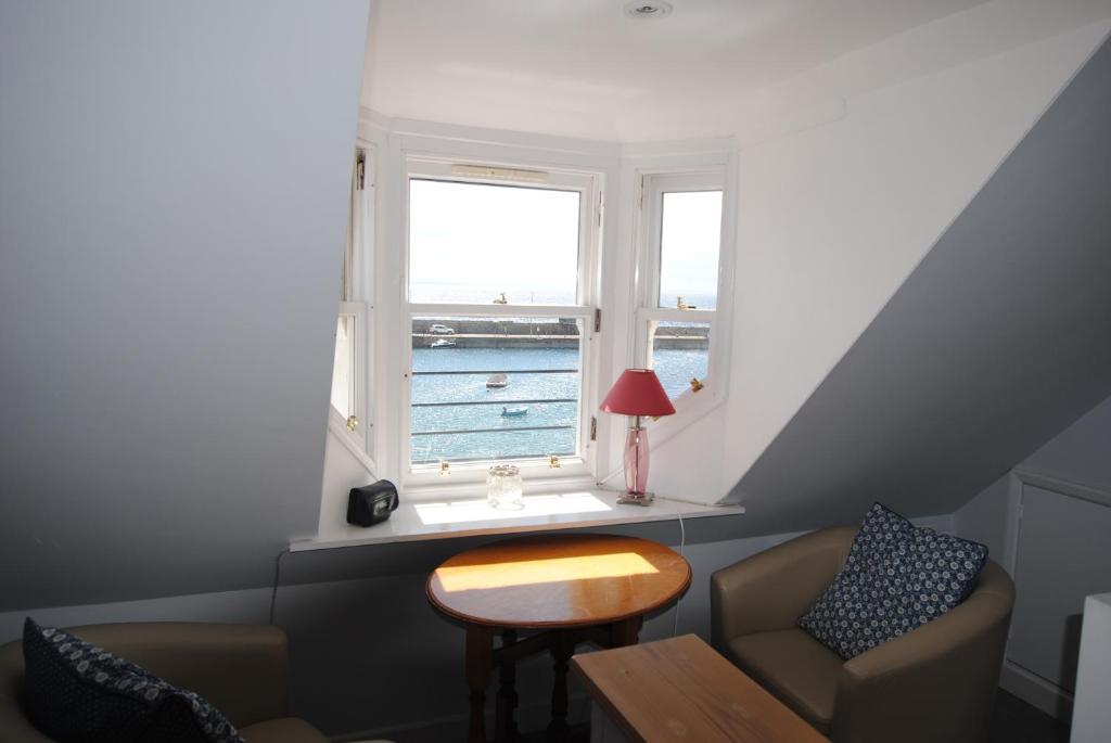 a living room with a chair and a window at Harbourside- home by the sea in coastal village in Saint Monance