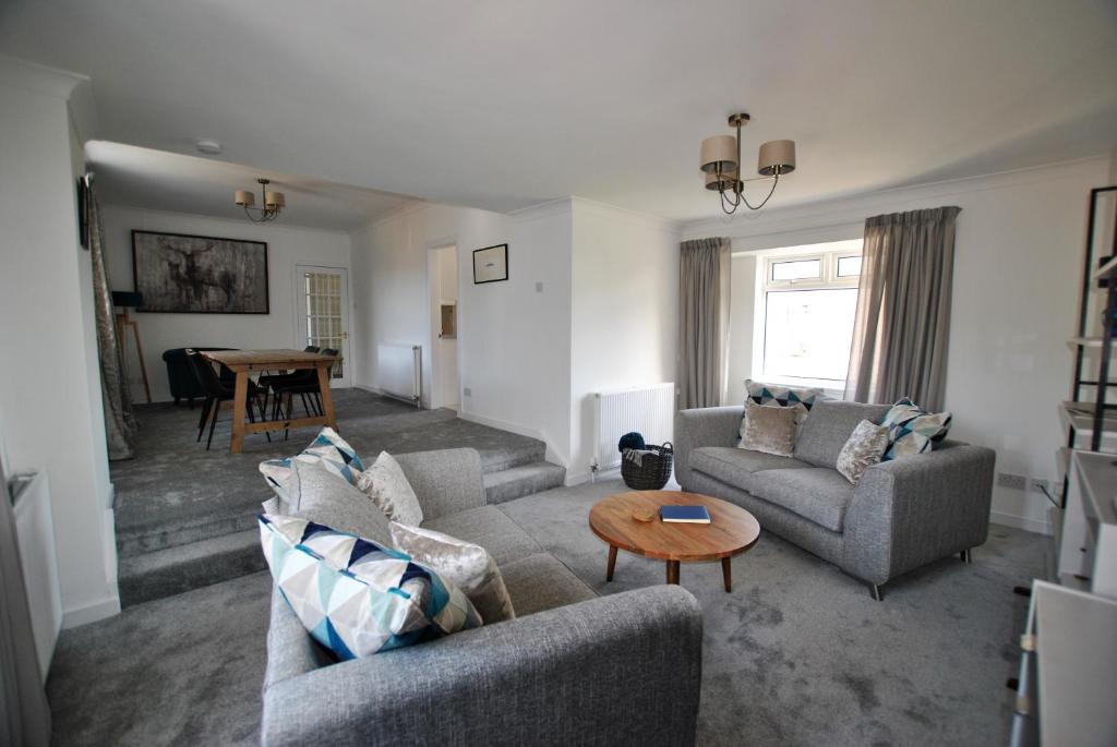 a living room with two couches and a table at Mariners Retreat- spacious apartment in Crail in Crail