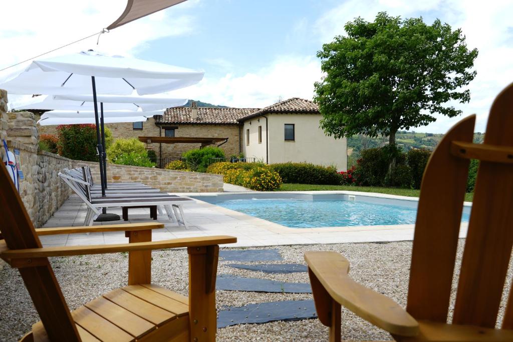 a patio with chairs and an umbrella and a pool at Grano - Casa Bella Vista in Force
