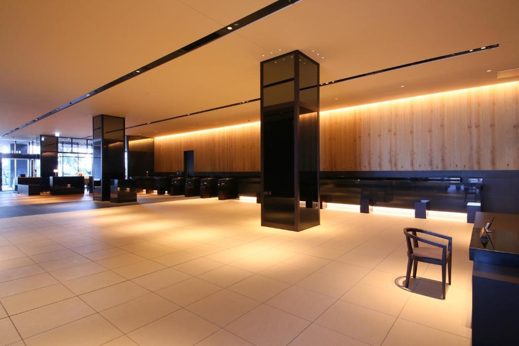 a empty lobby with a chair and lights at Hotel Gracery Shinjuku in Tokyo