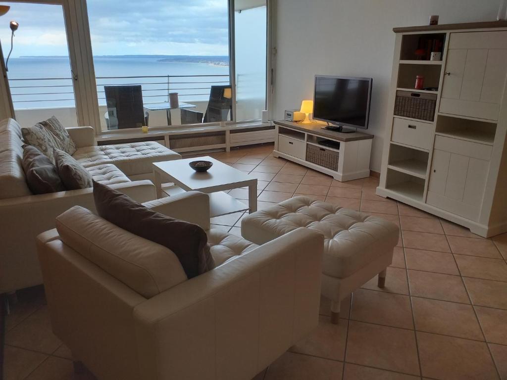 un soggiorno con divani, TV e oceano di Ferienwohnung 211 a Timmendorfer Strand