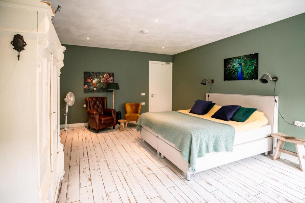 een slaapkamer met een bed en een groene muur bij B&B de Sfeerhoeve in Beilen