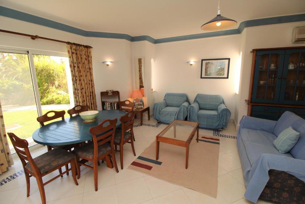 een woonkamer met een tafel en een blauwe bank bij SÃO RAFAEL BEACH VILLAGE 131 - Apartamento T2 Praia de São Rafael - Albufeira in Albufeira