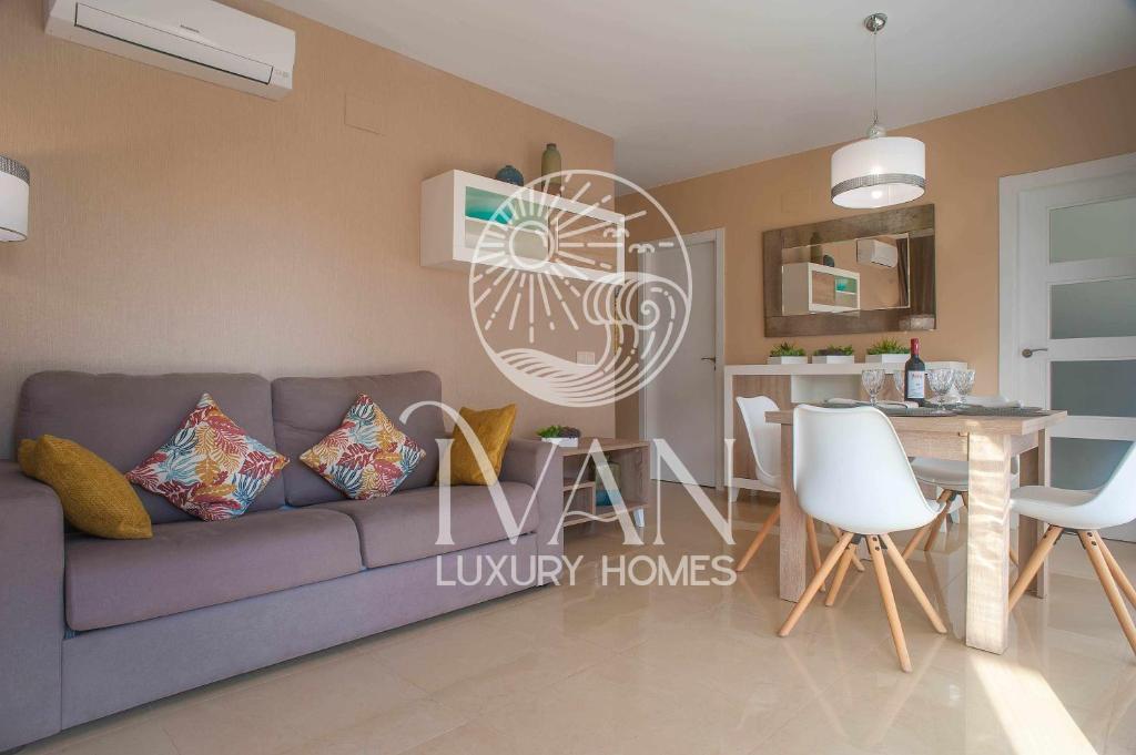 uma sala de estar com um sofá roxo e uma cozinha em Casa Paraíso Iván Luxury Homes 1ª Linea de Playa em Oropesa del Mar