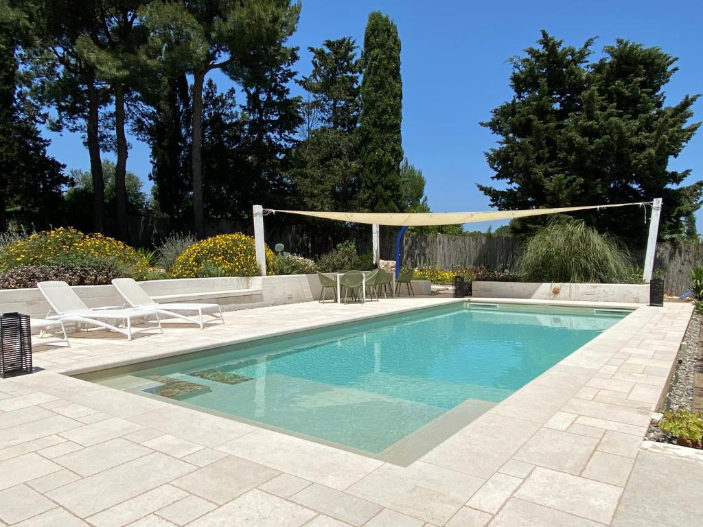 a swimming pool with two chairs and a gazebo at Casa 34 in Ceglie Messapica