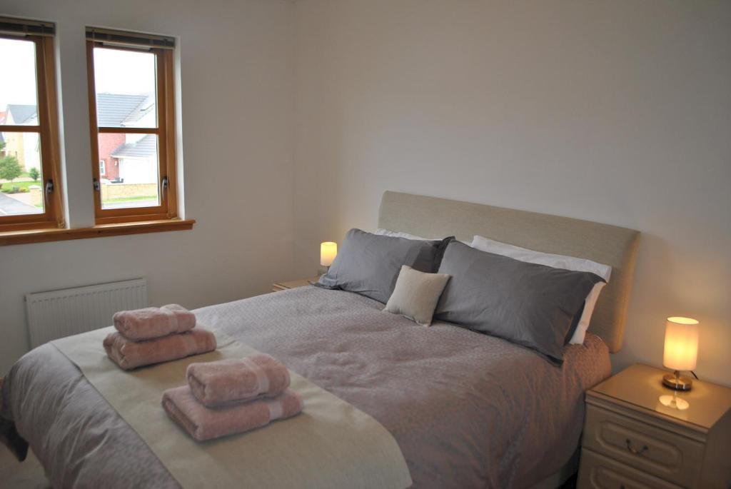 a bedroom with a bed with two towels on it at Faolin- superb detached family villa East Neuk in Anstruther