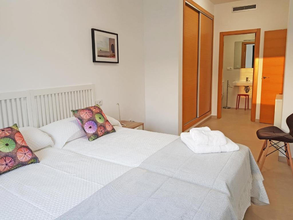 - une chambre avec un grand lit blanc et des oreillers dans l'établissement Sunny apartment great for Cycling, 300mb wifi, à Xaló