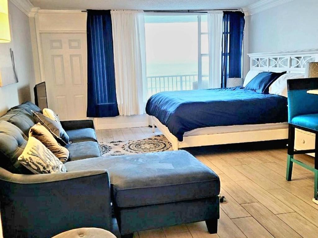- un salon avec un lit et un canapé dans l'établissement Direct Oceanfront With Balcony, à Daytona Beach