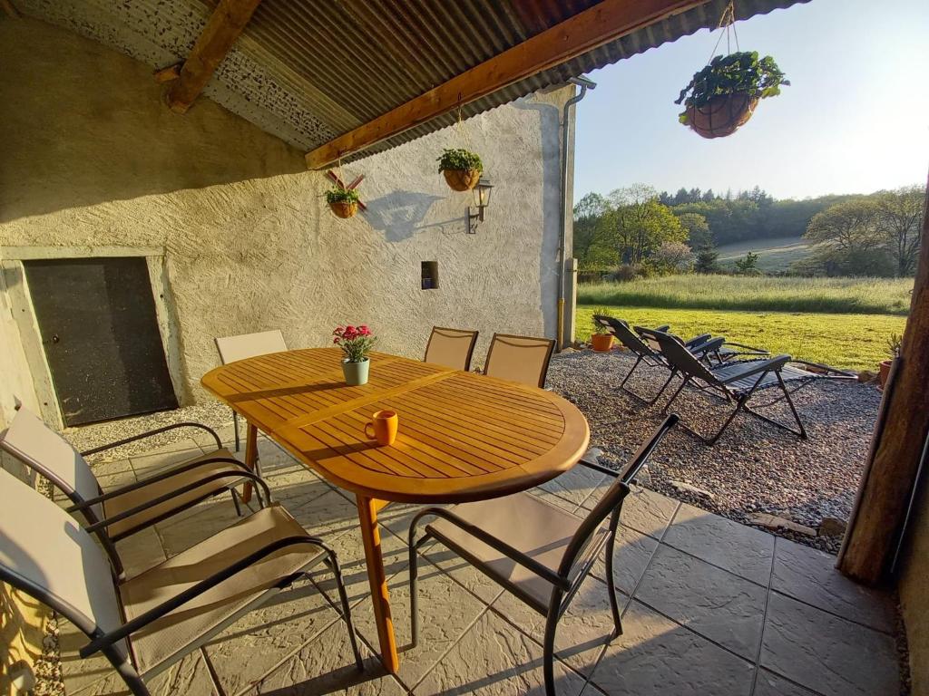 einen Holztisch und Stühle auf einer Terrasse in der Unterkunft Macorn 