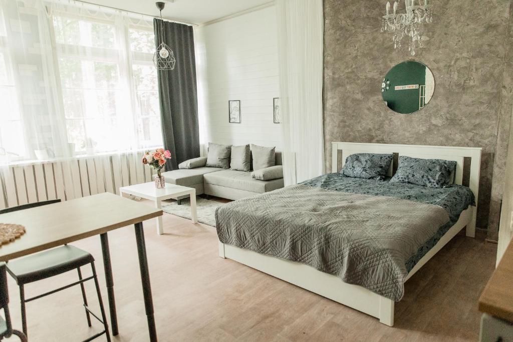 een slaapkamer met een bed en een woonkamer bij Studio type apartment in Ķegums in Ķegums