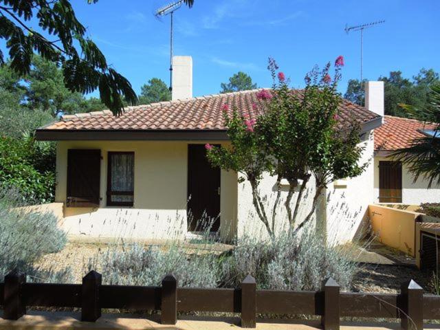 uma pequena casa com uma árvore em frente em Entrade - Seignosse - Villa patio dans quartier calme entre le Golf et les Plages em Seignosse