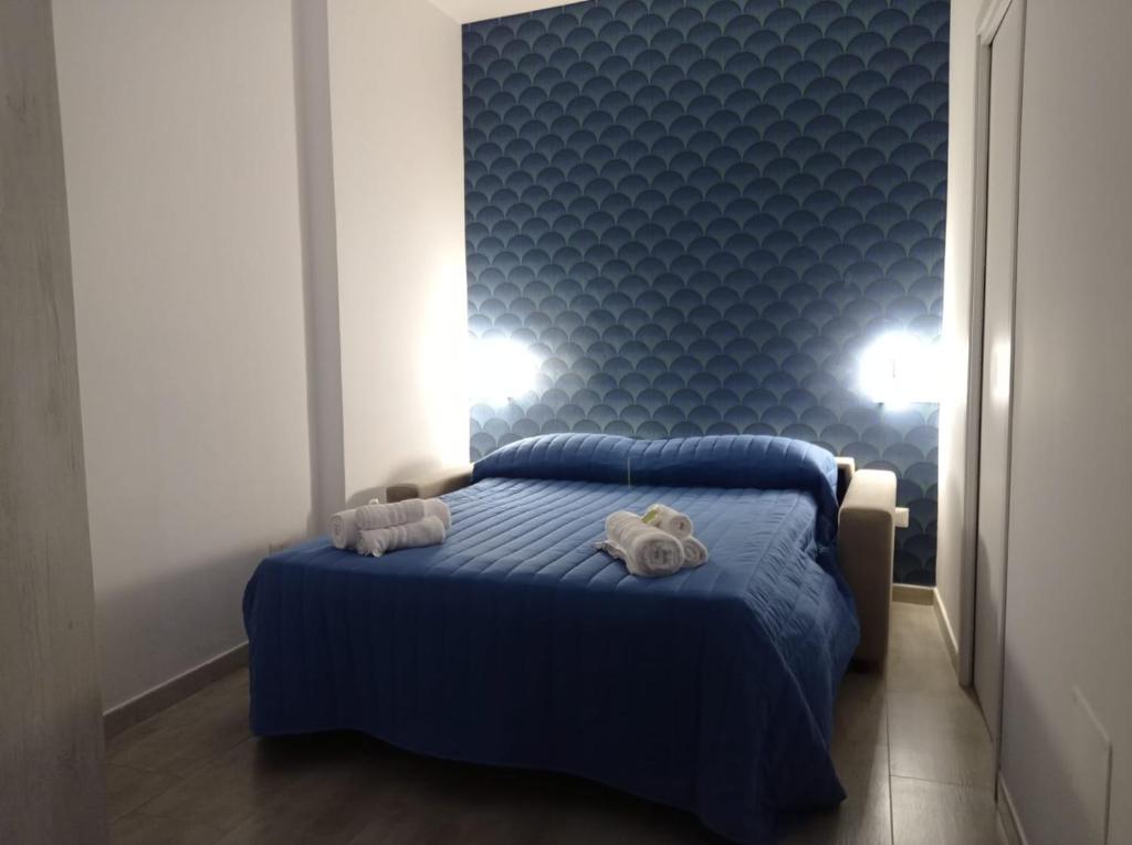 Un dormitorio con una cama azul con toallas. en La pergola home, en Barletta