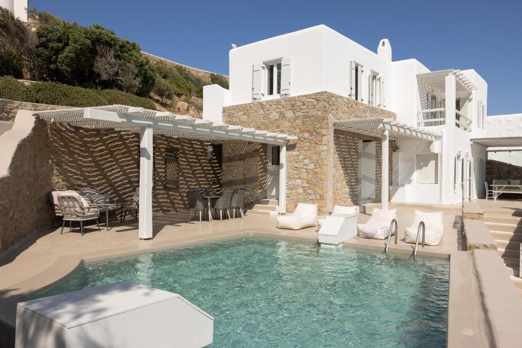 une villa avec une piscine et une maison dans l'établissement Amaris Mykonian Residence, à Ornos