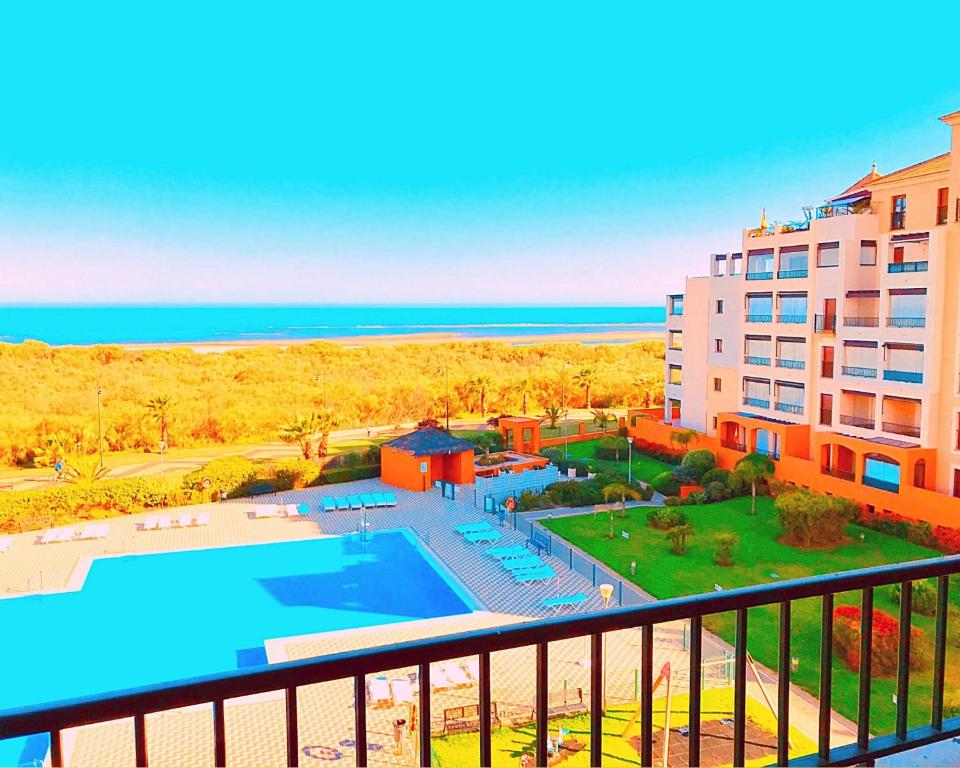 vista para um resort com piscina e oceano em Los Pelícanos, Isla Canela By AC REAL na Isla Canela