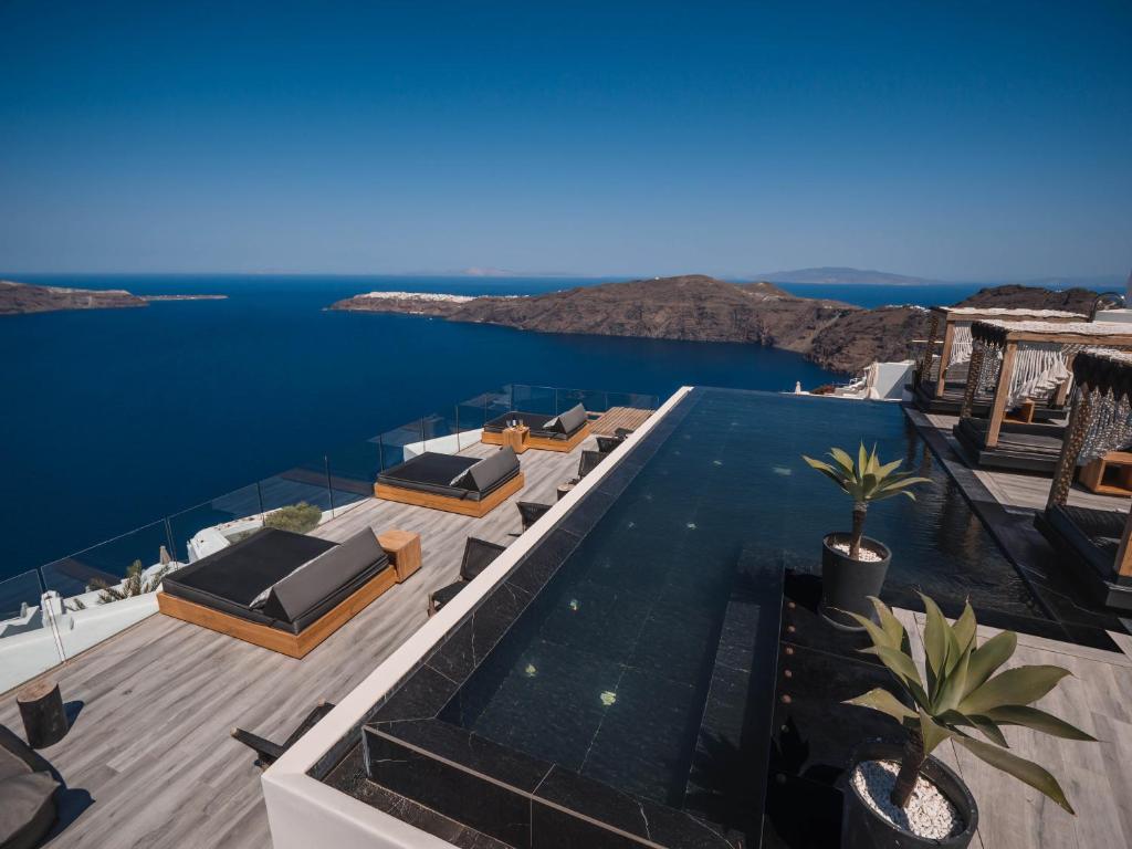 a house with a swimming pool with a view of the ocean at Galaxy Suites & Villas in Imerovigli